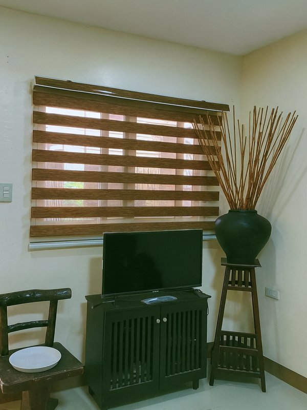 Wooden color zebra roller blinds in a modern living room interior